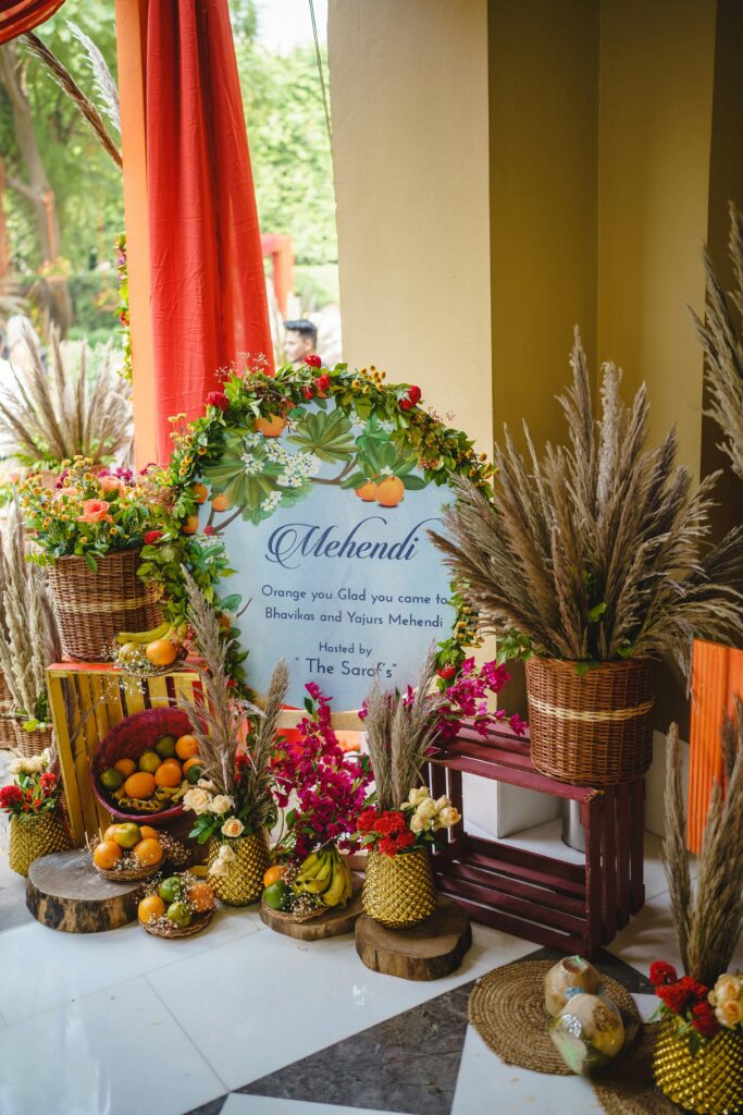 Bright and colorful Mehendi ceremony setup featuring fruits, flowers, and traditional decor elements.